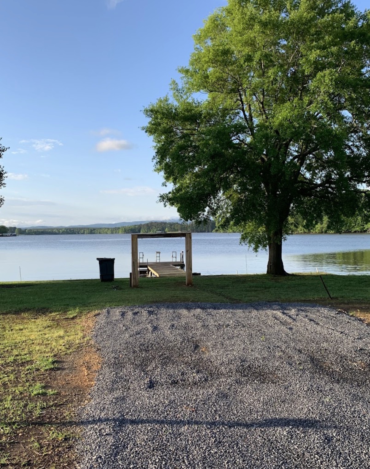 Wooden dock and lone tree overlooking Weiss Lake at sunrise